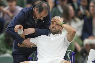 Dimitrov receives treatment during Wimbledon match