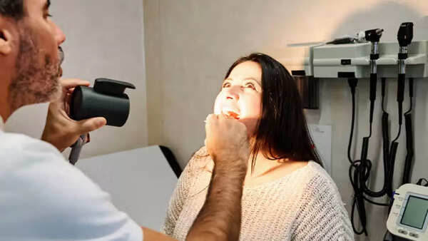 A dentist performing an oral cancer screening on a patient